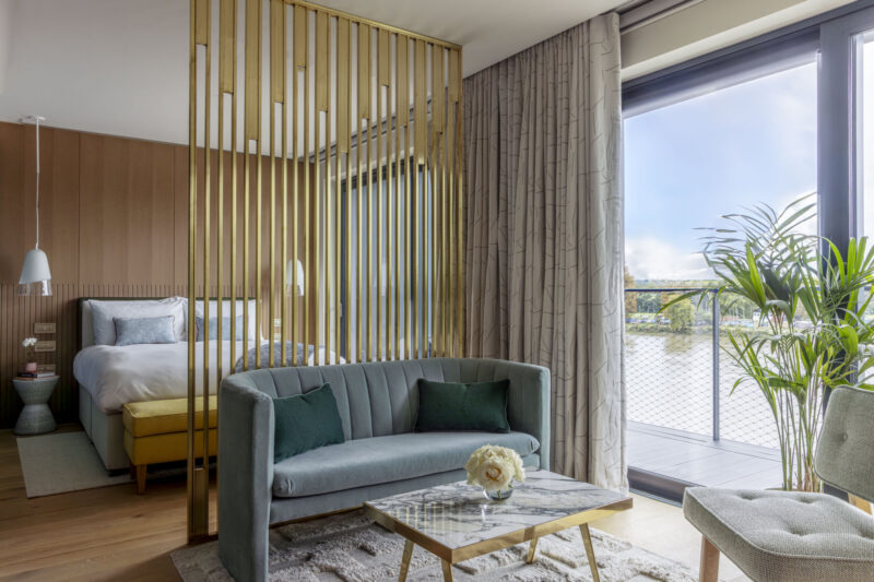 junior suite with blue sofa and view of the river thames