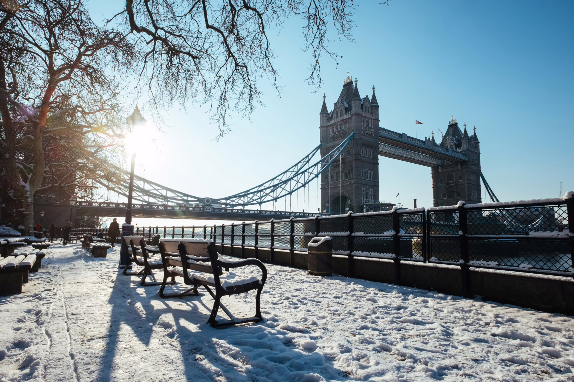 Tower Bridge and the riverside walk with benches all covered in snow.