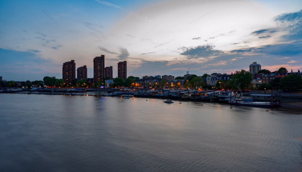 The River Thames at dusk, with lights beginning to shine across the river.